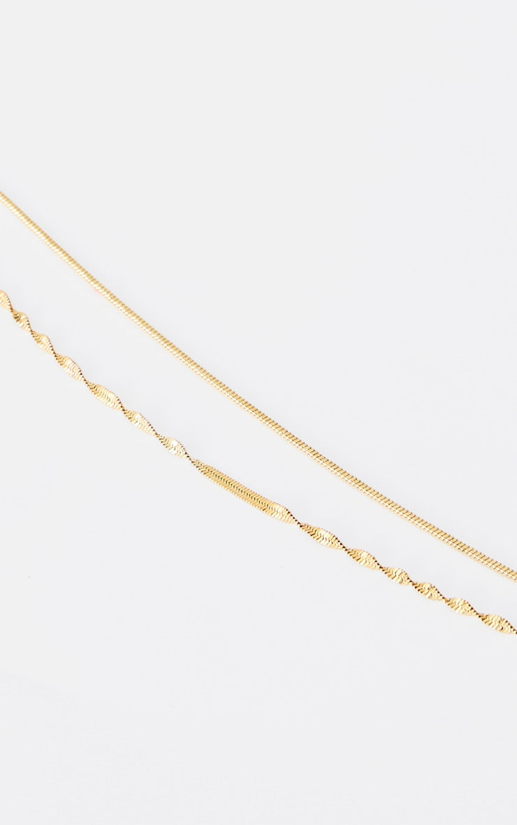 https://cdn-img.prettylittlething.com/f/a/d/f/fadfe6f2a779a647812d1052c853b5cefc52ba3b_CNK4198_3_gold_water_resistant_double_layer_twist_necklace.jpg